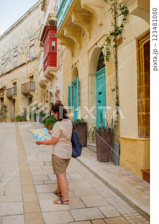 Woman traveler exploring touristic town Birgu on Malta island with a map Woman traveler exploring touristic town Birgu on Malta island with a map 123481080