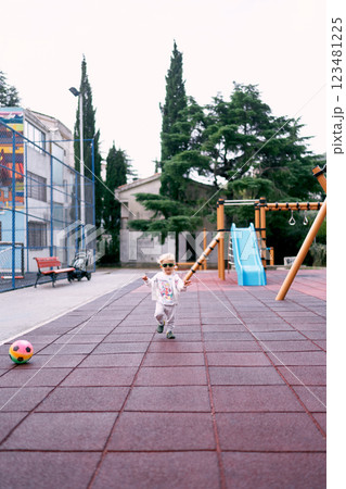 Little girl in a tracksuit runs on the playground. High quality photo Little girl in a tracksuit runs on the playground. High quality photo 123481225