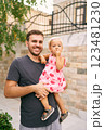 Smiling dad with a little girl in his arms near a stone fence. Portrait. High quality photo 123481230