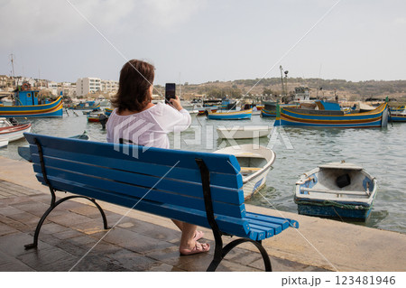 Woman traveler making photographs on a smartphone in fishing village Marsaxlokk on Malta 123481946