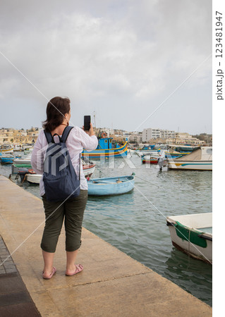Woman travel blogger filming a video in fishing village Marsaxlokk on Malta Woman travel blogger filming a video in fishing village Marsaxlokk on Malta 123481947