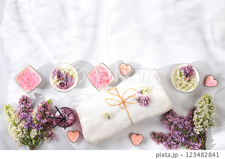 Fragrant pink salt, lilac water and lilac flowers. Spa and wellness composition, aromatherapy and skin care, lifestyle and organic cosmetics concept, salon invitation and advertisement, selective 123482841