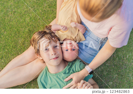 Young mother, teenage son, and one-month-old baby enjoying quality family time in the park. Multigenerational bonding and outdoor family love concept Young mother, teenage son, and one-month-old baby enjoying quality family time in the park. Multigenerational bonding and outdoor family love concept 123482863