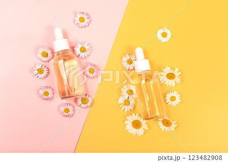 Bottles with lotion with chamomile extracts and flowers on a light background, the concept of natural organic cosmetics, advertising for spa and store, top view.. Bottles with lotion with chamomile extracts and flowers on a light background, the concept of natural organic cosmetics, advertising for spa and store, top view.. 123482908