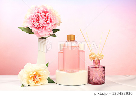 Lotion bottles with rose extracts and peony flowers on elegant background, natural organic cosmetics concept, spa and store advertising, minimal composition, selective focus 123482930