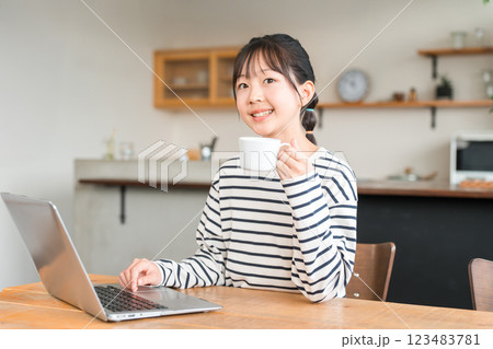 自宅のリビング・スタディコーナーでパソコンを使う小学生・中学生の女の子 自宅のリビング・スタディコーナーでパソコンを使う小学生・中学生の女の子 123483781