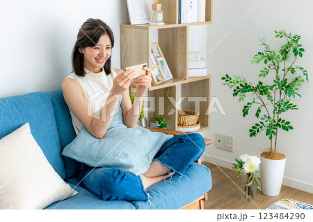 スマホを見る笑顔の女性 スマホを見る笑顔の女性 123484290
