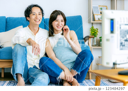 テレビを見てリビングでくつろぐ若い夫婦 テレビを見てリビングでくつろぐ若い夫婦 123484297