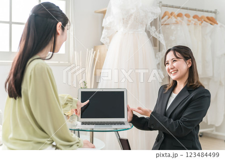 ウェディングプランナーとドレス選びの打ち合わせをする女性 ウェディングプランナーとドレス選びの打ち合わせをする女性 123484499