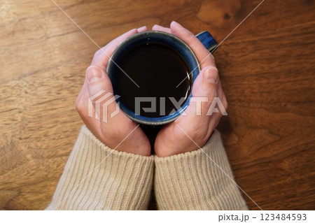 温かいコーヒーの入ったマグカップを持つ女性の手元 123484593