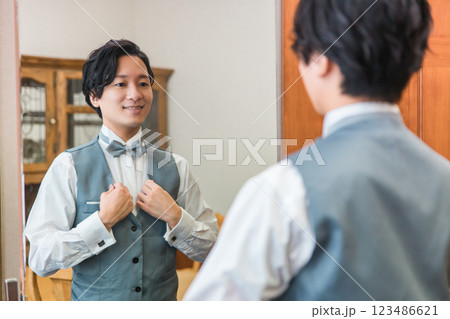 控え室・ブライズルームで結婚式・挙式・披露宴の準備をする新郎・花婿 控え室・ブライズルームで結婚式・挙式・披露宴の準備をする新郎・花婿 123486621