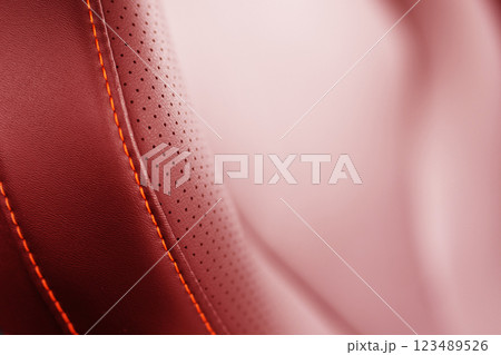 Car red leather interior. Part of red leather car seat details with white stitching. Interior of prestige car. Comfortable perforated leather seats. Perforated leather. 123489526
