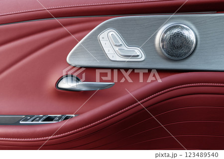 Door handle with Power seat control buttons of a luxury passenger car. Red leather interior of the luxury modern car. Modern car interior details Door handle with Power seat control buttons of a luxury passenger car. Red leather interior of the luxury modern car. Modern car interior details 123489540