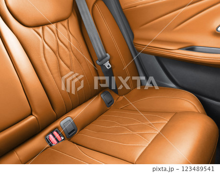 Back passenger black seats in modern luxury car. Brown perforated leather with white stitching. Car details. Leather comfortable seats. Car interior details 123489541