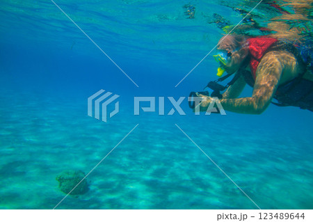 Man with photo camera taking photos and snorkeling underwater by coral reef in the Red sea, Egypt 123489644
