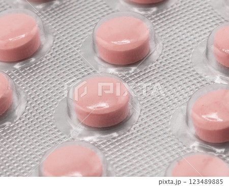 Macro shot pile of tablets pill in silver blister packaging isolated on white background. Aluminium foil blister pack. Pharmacy products. Medicine pills and drugs close up. Pills background 123489885