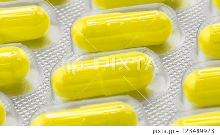 Macro shot pile of tablets pill in silver blister packaging isolated on white background. Aluminium foil blister pack. Pharmacy products. Medicine pills and drugs close up. Pills background Macro shot pile of tablets pill in silver blister packaging isolated on white background. Aluminium foil blister pack. Pharmacy products. Medicine pills and drugs close up. Pills background 123489923
