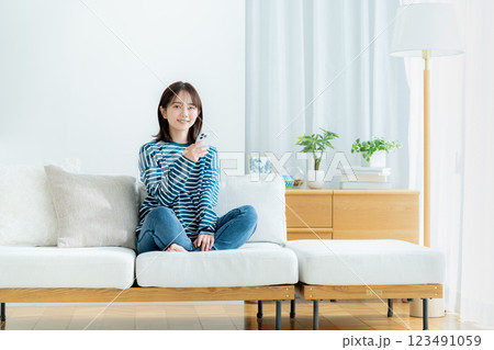 部屋でスマホを操作する若い女性 部屋でスマホを操作する若い女性 123491059