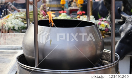 A pot for holding fuel for burning incense sticks and candles to worship sacred objects of Buddhists or Hindu Brahmins	 123491269