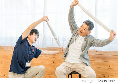 老人ホームでタオル体操・運動・リハビリするシニア・高齢者の男性と理学療法士・介護士・トレーナー 老人ホームでタオル体操・運動・リハビリするシニア・高齢者の男性と理学療法士・介護士・トレーナー 123491447
