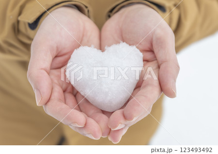 ハート型の雪を持つ女性 123493492