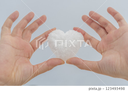 ハート型の雪を持つ女性の手 123493498