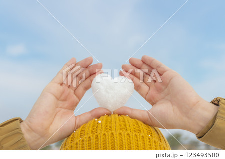 ハート型の雪を頭の上に持つ女性 123493500