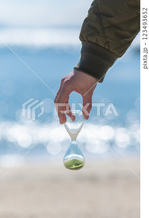 海辺で砂時計を持っている人 123493652
