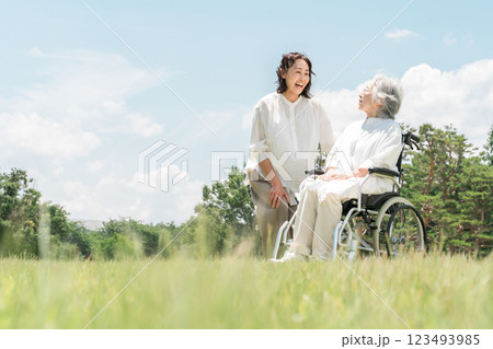 公園にいる車椅子に乗ったシニア女性と介助する女性(介護・親子・老人ホーム) 公園にいる車椅子に乗ったシニア女性と介助する女性(介護・親子・老人ホーム) 123493985