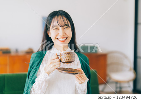 ソファに座ってコーヒーを飲む女性 ソファに座ってコーヒーを飲む女性 123494726