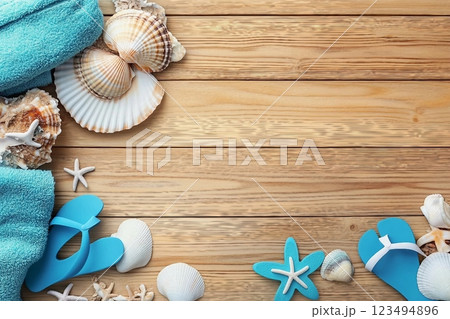 Different seashells with towels and flip flops on brown wooden table 123494896