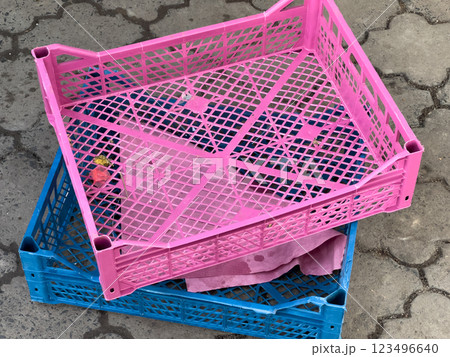 Stacked crates in bright colors rest on a patterned pavement, reflecting a lively market atmosphere filled with activity and goods ready for sale 123496640