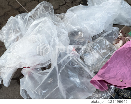 Various pieces of discarded plastic and debris are scattered on the pavement, emphasizing the pressing issues of urban pollution and waste accumulation in public spaces 123496643