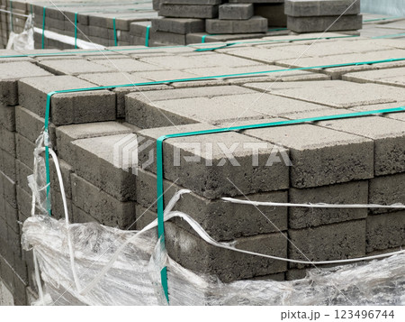 Cobblestones are neatly stacked and secured with straps, ready for a construction project. The site showcases organized materials essential for paving tasks Cobblestones are neatly stacked and secured with straps, ready for a construction project. The site showcases organized materials essential for paving tasks 123496744