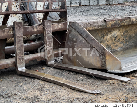 A robust bulldozer equipped with a grader attachment is stationed at a busy construction site, poised for upcoming earth-moving projects A robust bulldozer equipped with a grader attachment is stationed at a busy construction site, poised for upcoming earth-moving projects 123496871