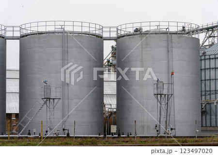 Large fuel storage tanks stand side by side in an industrial setting, utilized for storing various fuels. The structures highlight the importance of energy resources 123497020