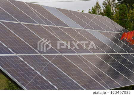Solar panels glisten under the midday sun in a serene rural setting, showcasing renewable energy's potential while blending harmoniously with nature Solar panels glisten under the midday sun in a serene rural setting, showcasing renewable energy's potential while blending harmoniously with nature 123497085