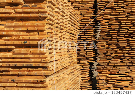 Stack of fresh pine boards in a sawmill warehouse. Lumber, boards lie in a pile at the sawmill. Lumber Industry 123497437