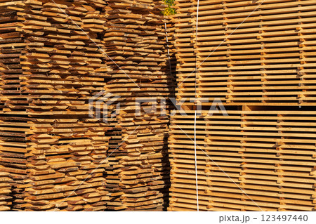 Large stacks of wooden planks at the sawmill yard. Sawing drying and marketing of wood. Pine lumber Large stacks of wooden planks at the sawmill yard. Sawing drying and marketing of wood. Pine lumber 123497440