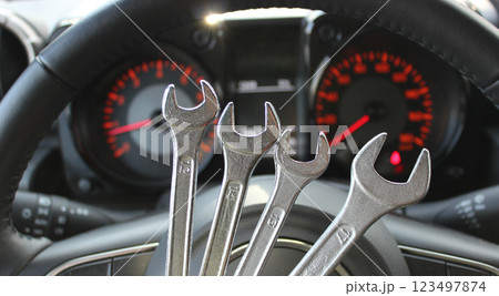 Four Different Size Chrome Spanners In Front Of Defocused Instrument Cluster With Red Backlight 123497874