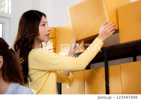 Young asian woman organizing packages for preparing with shipping and delivery. 123497899