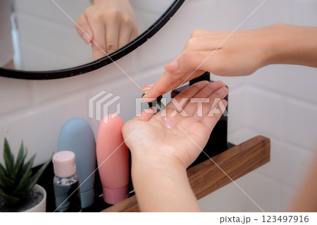 Closeup hand of woman dispenser for liquid soap in bathroom at home, woman washing with lotion. Closeup hand of woman dispenser for liquid soap in bathroom at home, woman washing with lotion. 123497916
