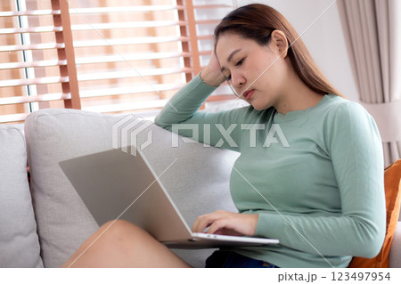 Young asian businesswoman working laptop with stress and frustrated in living room. Young asian businesswoman working laptop with stress and frustrated in living room. 123497954