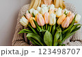 A woman holding a bouquet of white and pink tulips 123498707