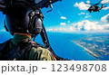 A man in a military uniform is looking out the window of a helicopter 123498708