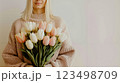 A woman holding a bouquet of white and pink tulips 123498709