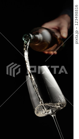 Pouring white wine in a glass. 123498816