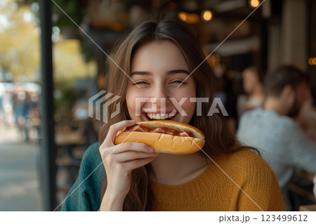 Smiling Woman Enjoying Hotdog Outdoors 123499612