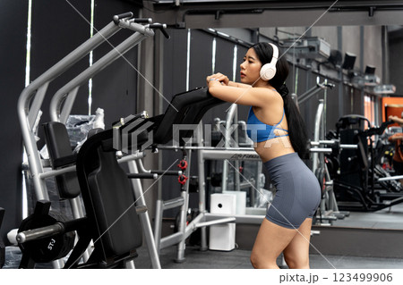 young woman exercising using tools in a sitting position 123499906