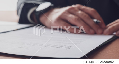 Hands of caucasian businessman resting on the bottom of a contract or document 123500621
